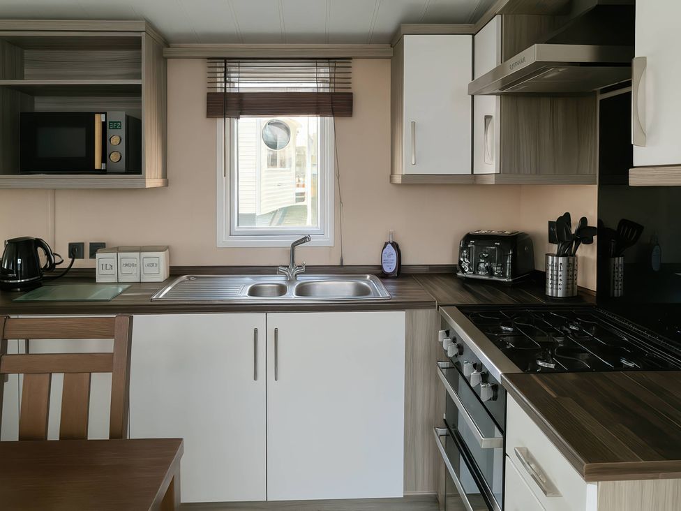 A kitchen with a sink and a stove at Whitehouse Leisure Park - Holiday Accommodation 19057, Towyn, Abergele