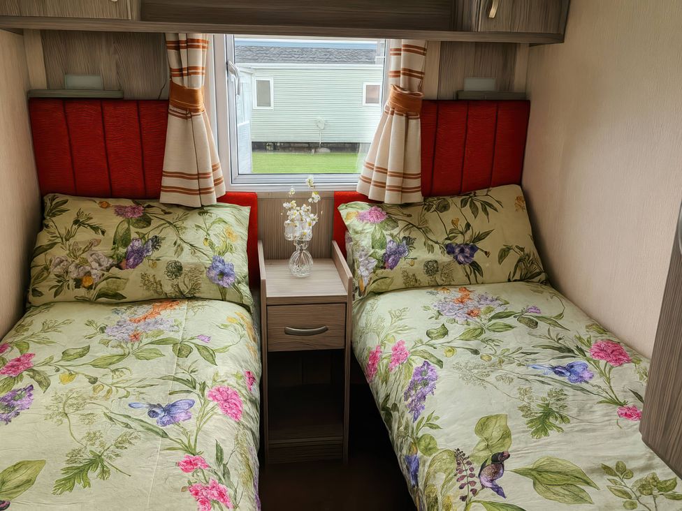 A bedroom with two beds and a nightstand at Whitehouse Leisure Park - Holiday Accommodation 19057, Towyn, Abergele