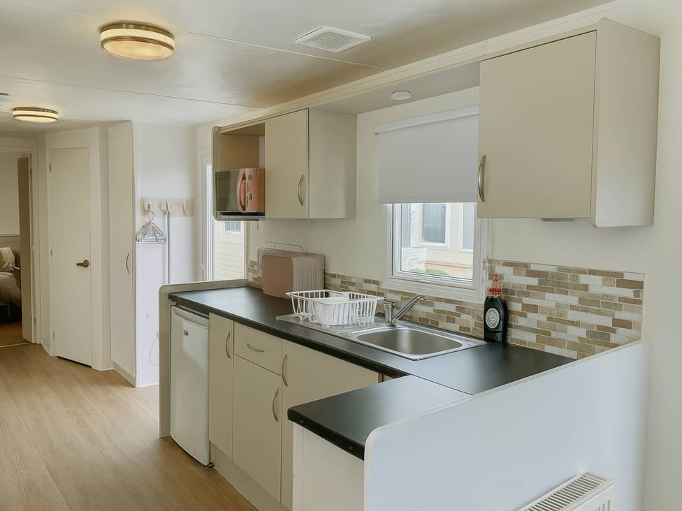 A kitchen with cabinets and a sink at Golden Gate Holiday Centre - Holiday Accommodation 19058 Towyn