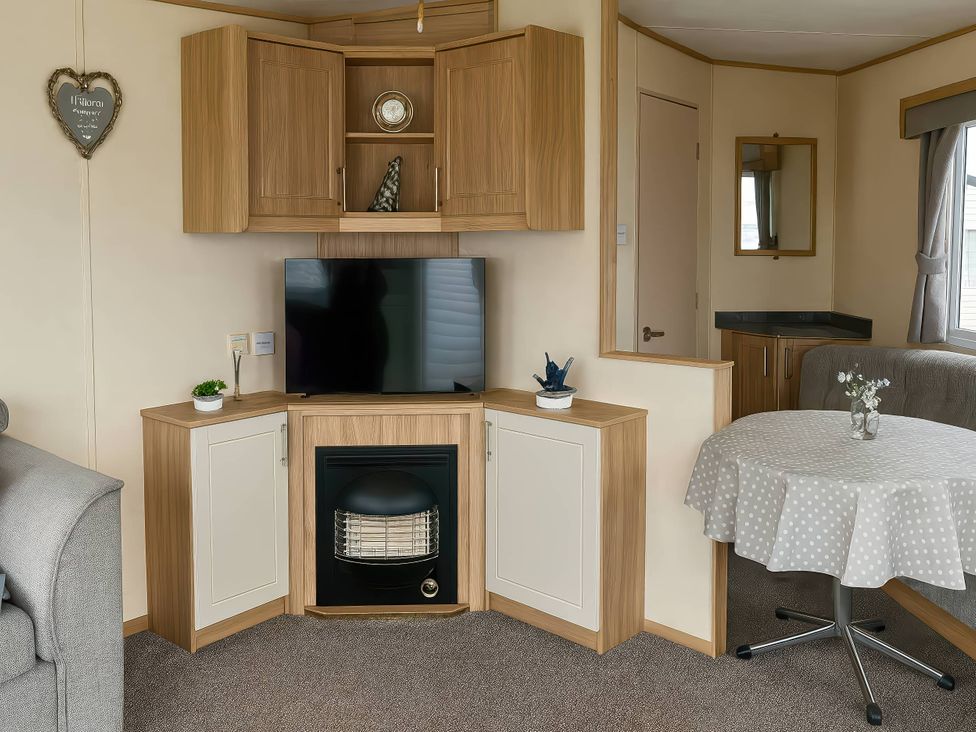 A living room with a television and fireplace at Golden Gate Holiday Centre - Holiday Accommodation 19059 Towyn