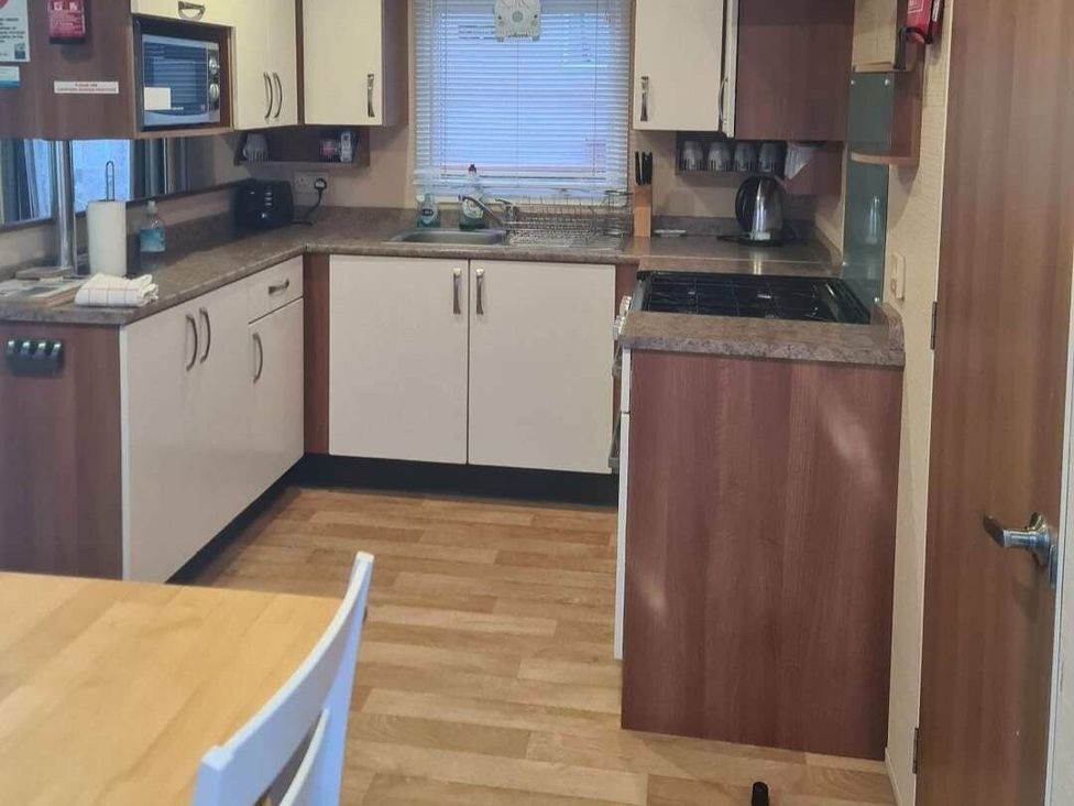 a kitchen with cabinets, countertop, and appliances at Littlesea Holiday Park - Holiday Accommodation 19270, Weymouth