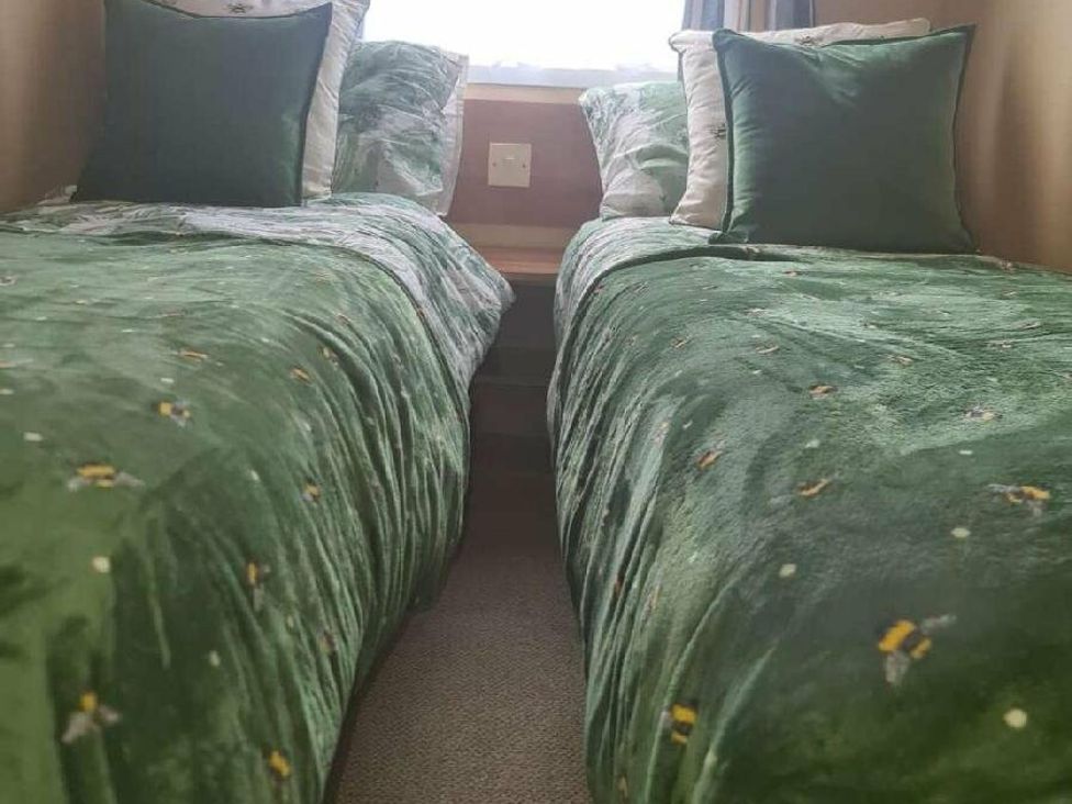 two single beds with green bedding and pillows at Littlesea Holiday Park - Holiday Accommodation 19270, Weymouth