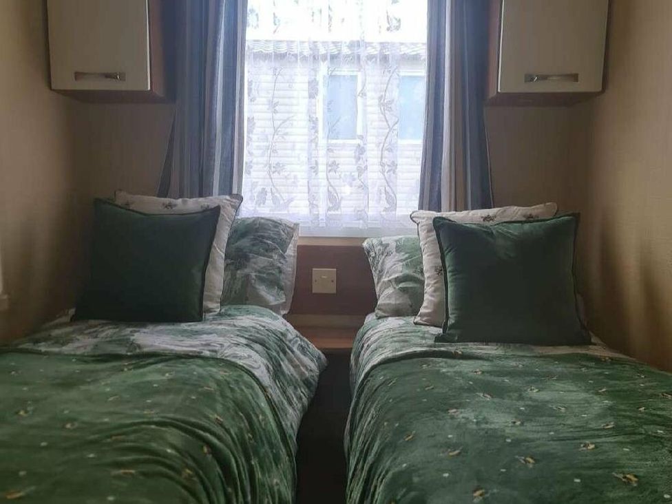 a bedroom with two twin beds and a window at Littlesea Holiday Park - Holiday Accommodation 19270 in Weymouth