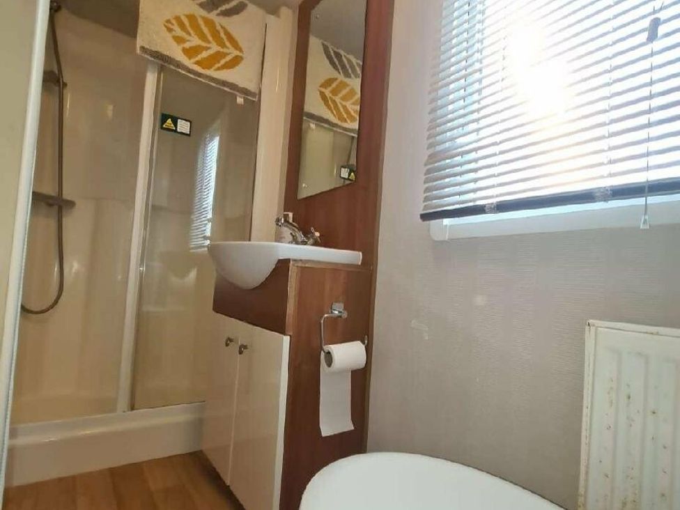 a bathroom with a shower, sink, mirror, and a toilet at Littlesea Holiday Park - Holiday Accommodation 19270 in Weymouth