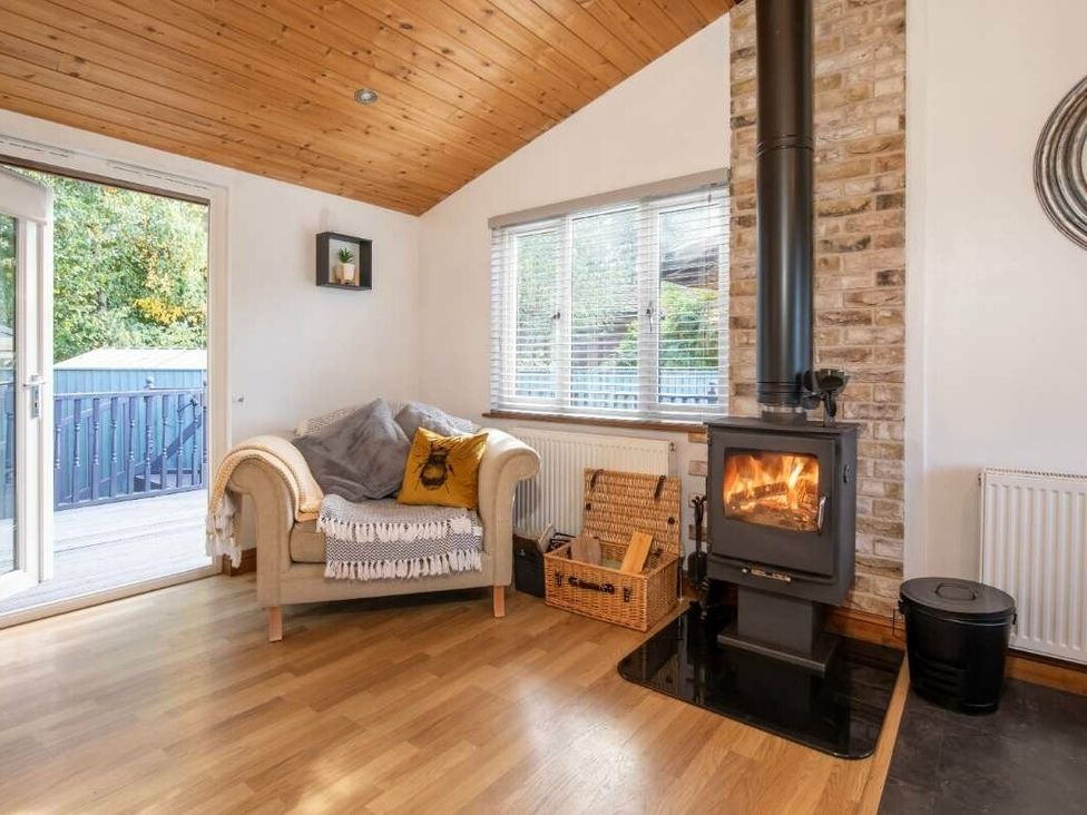 a living room with a beige sofa and wood-burning stove at Florida Keys Holiday Park - Holiday Accommodation 19291 York