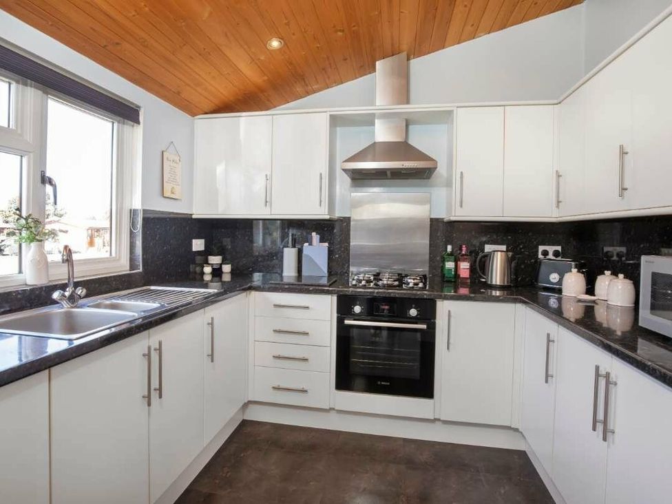 a kitchen with white cabinets and black countertops at Florida Keys Holiday Park - Holiday Accommodation 19291, York