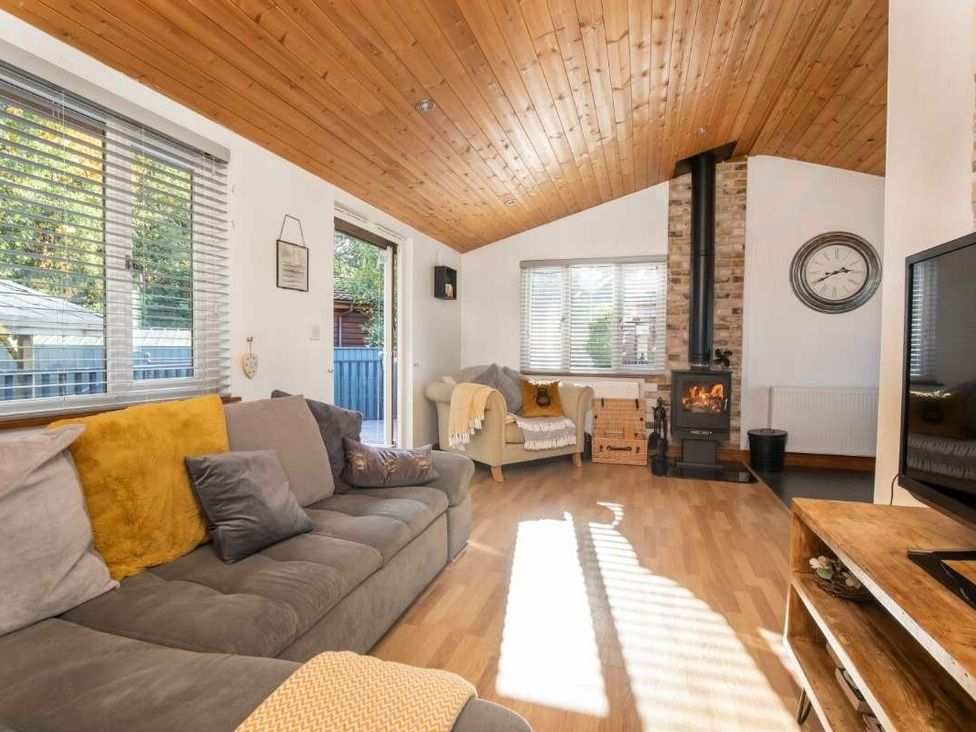a living room with a sofa, a fireplace, and large windows at Florida Keys Holiday Park - Holiday Accommodation 19291, York