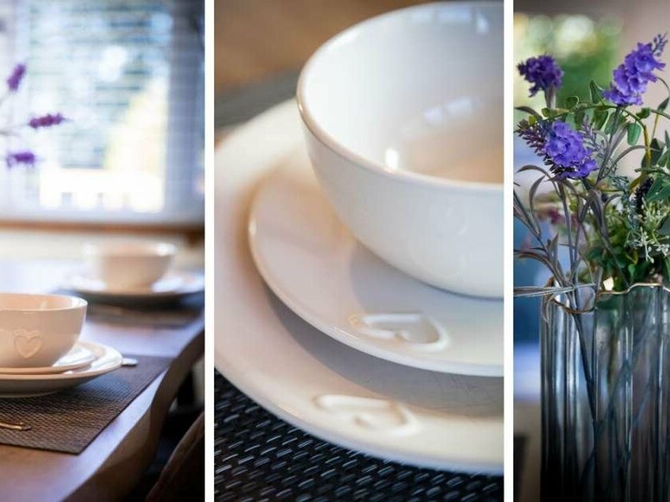 a table setting with white dishware and a vase of flowers at Florida Keys Holiday Park - Holiday Accommodation 19291 York