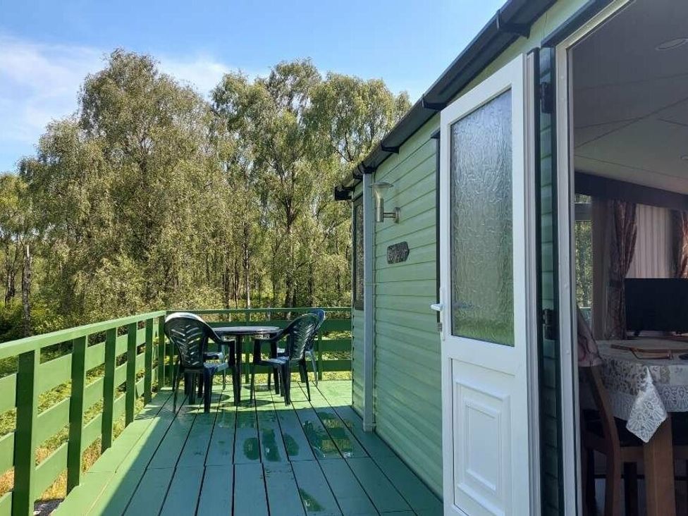 a balcony with a table and chairs overlooking trees at Hunters Quay Holiday Village - Holiday Accommodation 19798 Dunoon