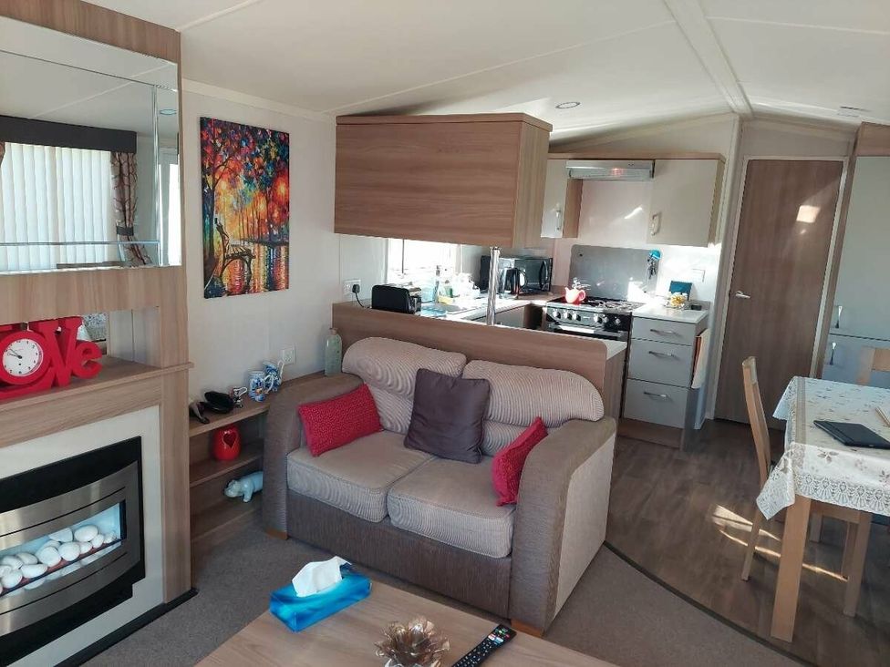 a living room with a couch and kitchenette at Hunters Quay Holiday Village - Holiday Accommodation 19798, Dunoon