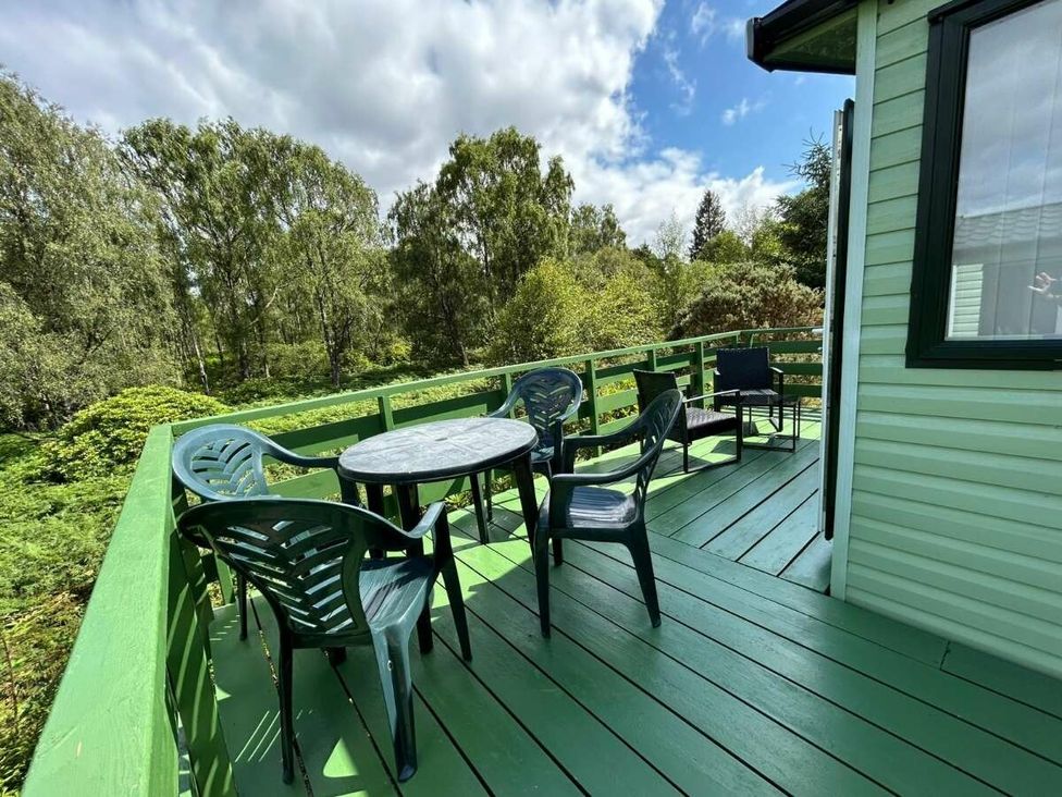 a balcony with a round table and chairs surrounded by greenery at Hunters Quay Holiday Village - Holiday Accommodation 19798 in Dunoon