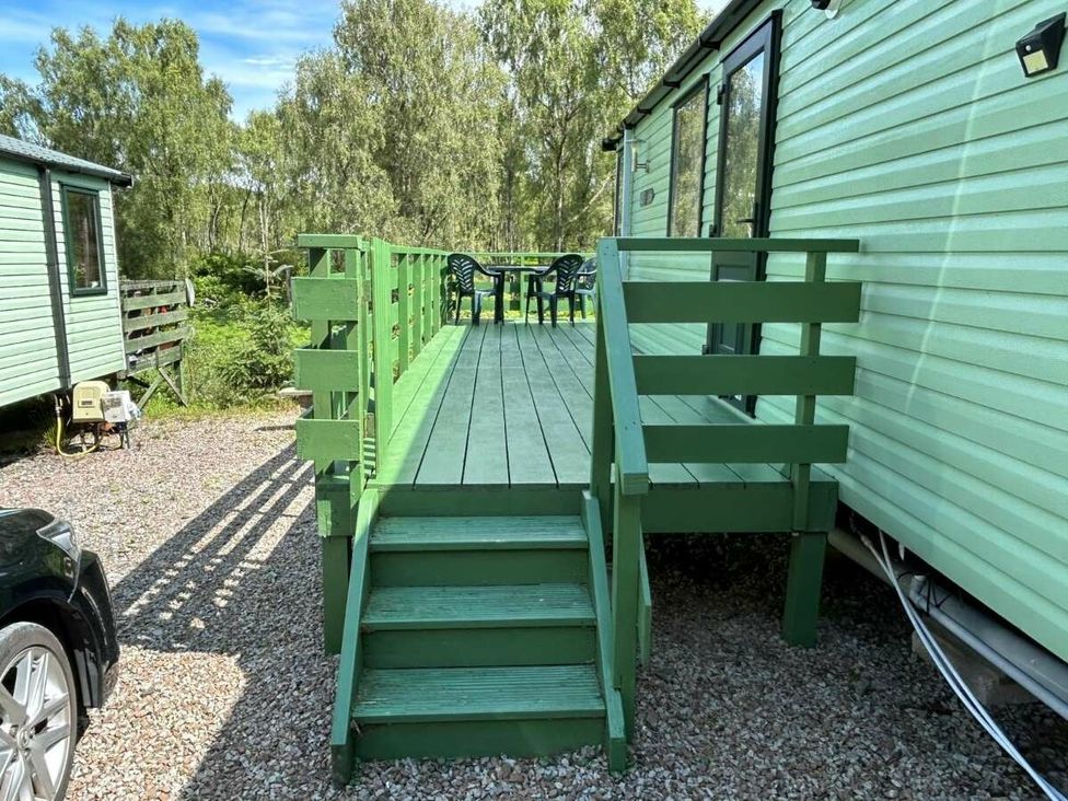 a wooden deck with green railings and steps leading to a static caravan at Hunters Quay Holiday Village - Holiday Accommodation 19798 Dunoon