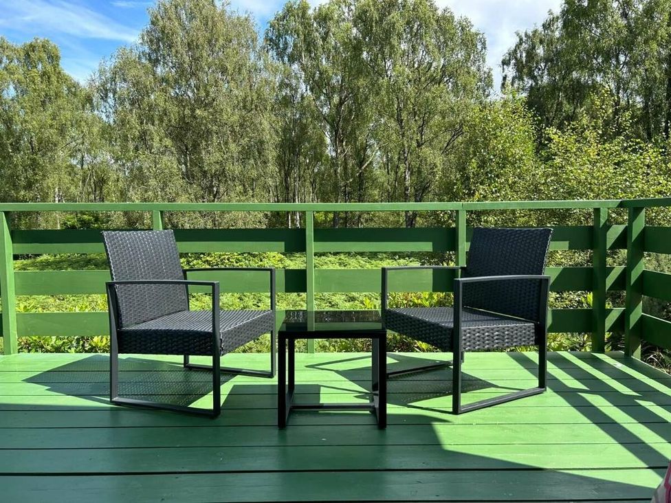 two chairs and a small table on a balcony overlooking greenery at Hunters Quay Holiday Village - Holiday Accommodation 19798, Dunoon