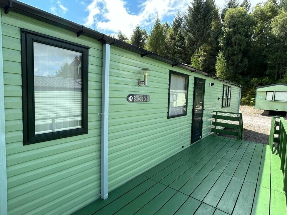 a green exterior of a mobile home with a wooden deck at Hunters Quay Holiday Village - Holiday Accommodation 19798 in Dunoon