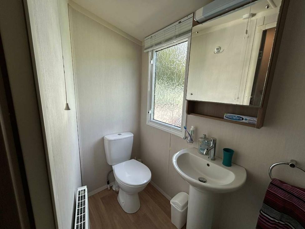 a bathroom with a toilet, sink, and mirror at Hunters Quay Holiday Village - Holiday Accommodation 19798 in Dunoon