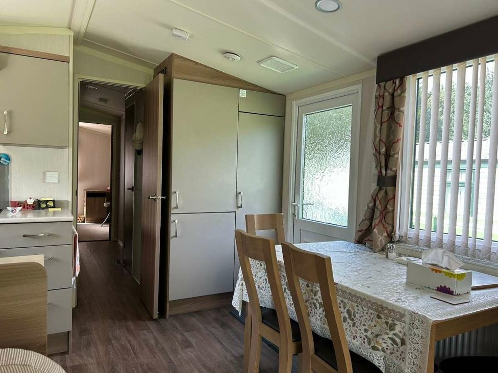 a dining area with a table and chairs next to a kitchen at Hunters Quay Holiday Village - Holiday Accommodation 19798, Dunoon