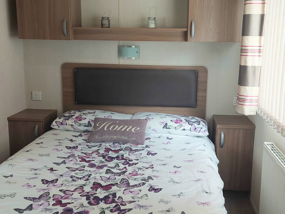 A bedroom with a bed and bedside tables at Hunters Quay Holiday Village in Dunoon
