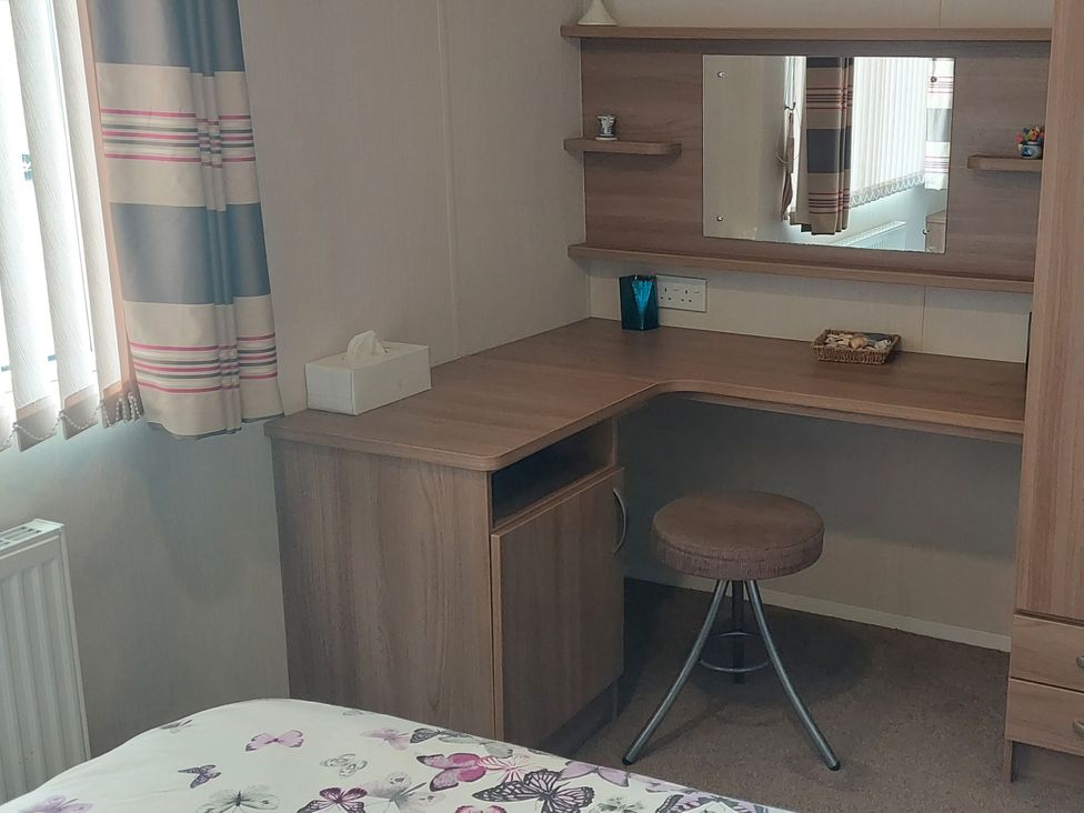 A desk with a mirror and chair at Hunters Quay Holiday Village in Dunoon