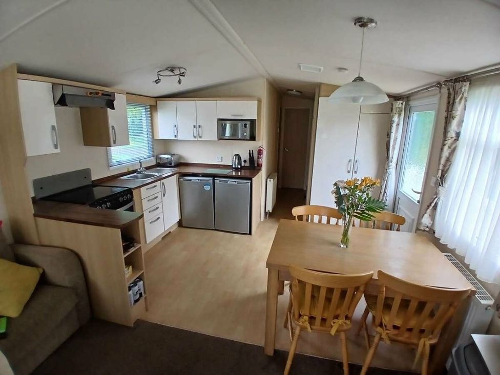 a kitchen with a dining table and chairs at Hoburne Cotswolds - Holiday Accommodation 20158 South Cerney