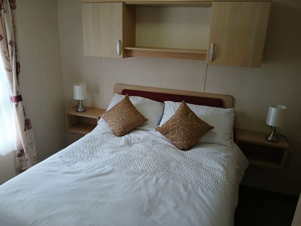 a bedroom with a double bed and two bedside tables at Hoburne Cotswolds - Holiday Accommodation 20158, South Cerney