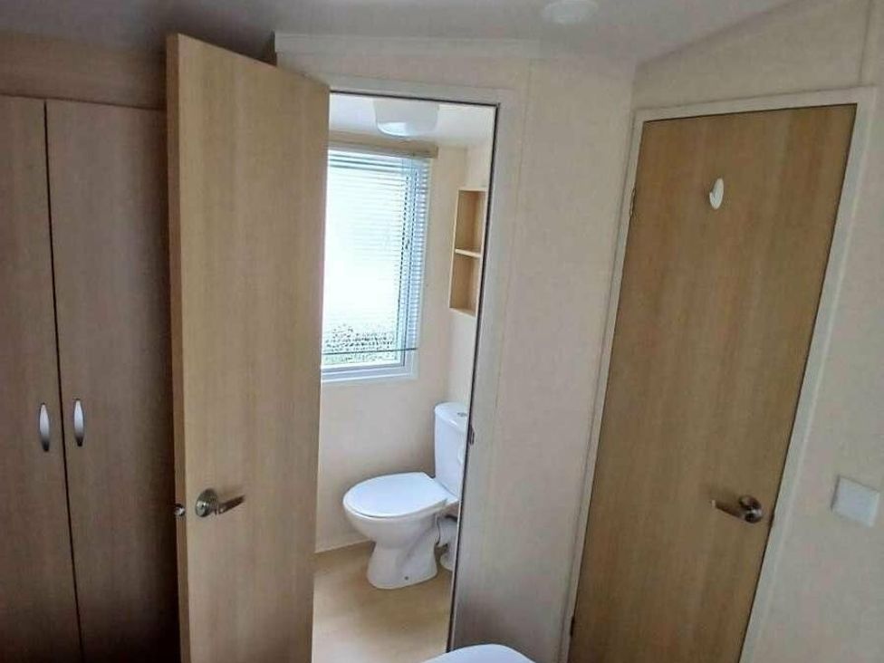 a bathroom view with a toilet and mirror at Hoburne Cotswolds - Holiday Accommodation 20158 in South Cerney