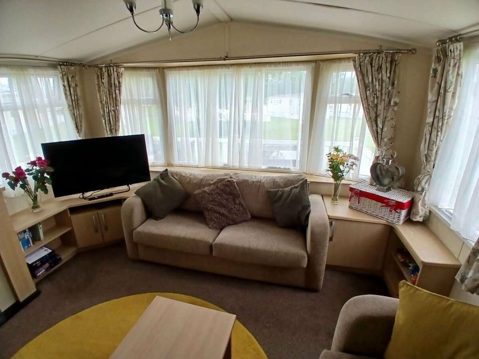 a living room with a sofa and television at Hoburne Cotswolds - Holiday Accommodation 20158 in South Cerney