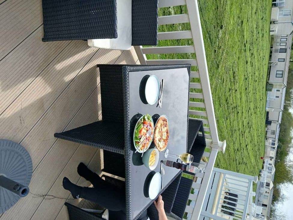 a dining table with food and drinks on a deck at Hoburne Cotswolds - Holiday Accommodation 20158 in South Cerney
