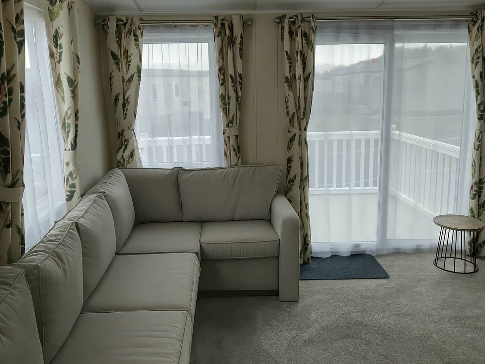 A living room with a sofa and curtains at Lakeland Leisure Park - Holiday Accommodation 20349 in Grange-Over-Sands