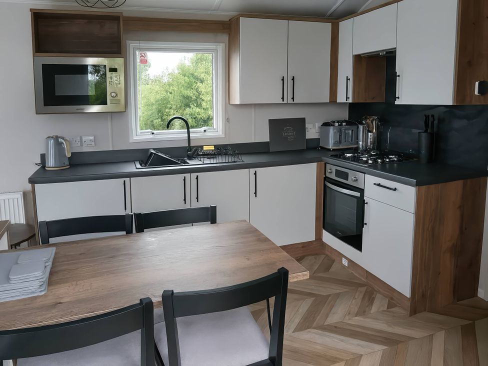 A kitchen with a table and chairs at Lakeland Leisure Park - Holiday Accommodation 20349 Grange-Over-Sands