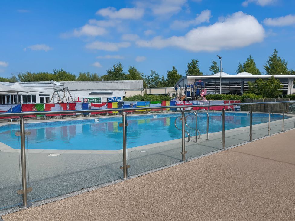 An outdoor swimming pool with slides and a fence at Lakeland Leisure Park - Holiday Accommodation 20349 in Grange-Over-Sands