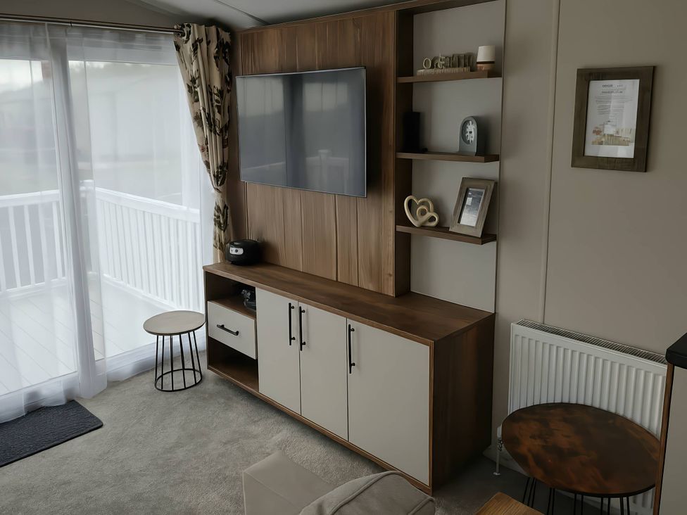 A living room with a television and storage cabinet at Lakeland Leisure Park - Holiday Accommodation 20349 Grange-Over-Sands