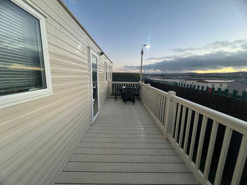 a deck area with chairs and a table at Golden Sands Kinmel Bay - Holiday Accommodation 20528 Rhyl
