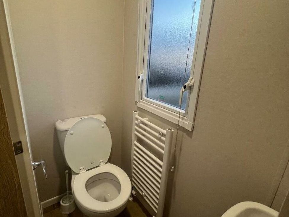 a bathroom with a toilet and radiator at Golden Sands Kinmel Bay - Holiday Accommodation 20528 in Rhyl