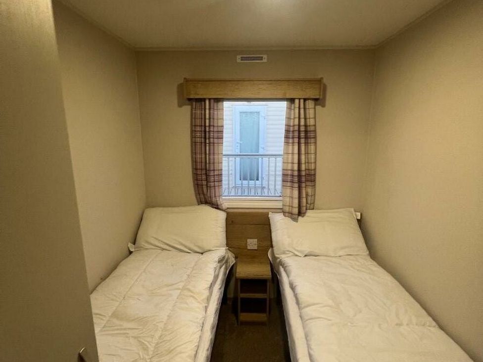 a bedroom with two single beds and a window at Golden Sands Kinmel Bay - Holiday Accommodation 20528 Rhyl