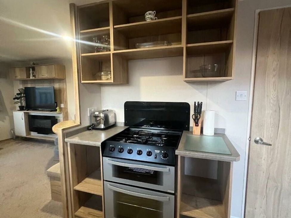 a kitchen area with a stove, shelves, and a countertop at Golden Sands Kinmel Bay - Holiday Accommodation 20528 in Rhyl