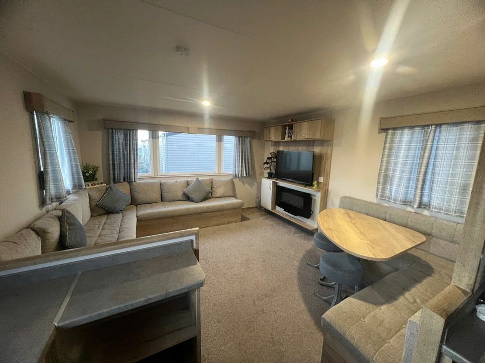 a living room with a sofa, table, and TV at Golden Sands Kinmel Bay - Holiday Accommodation 20528, Rhyl