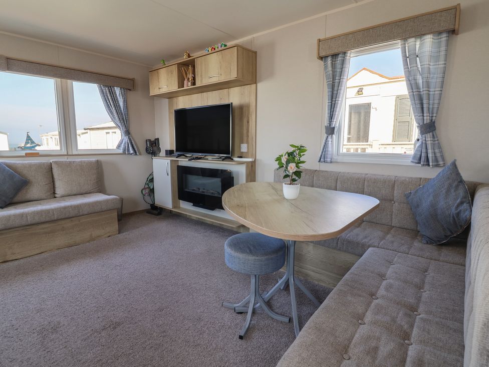 A living room with a sofa, table, and television at Golden Sands Kinmel Bay - 20528, Rhyl