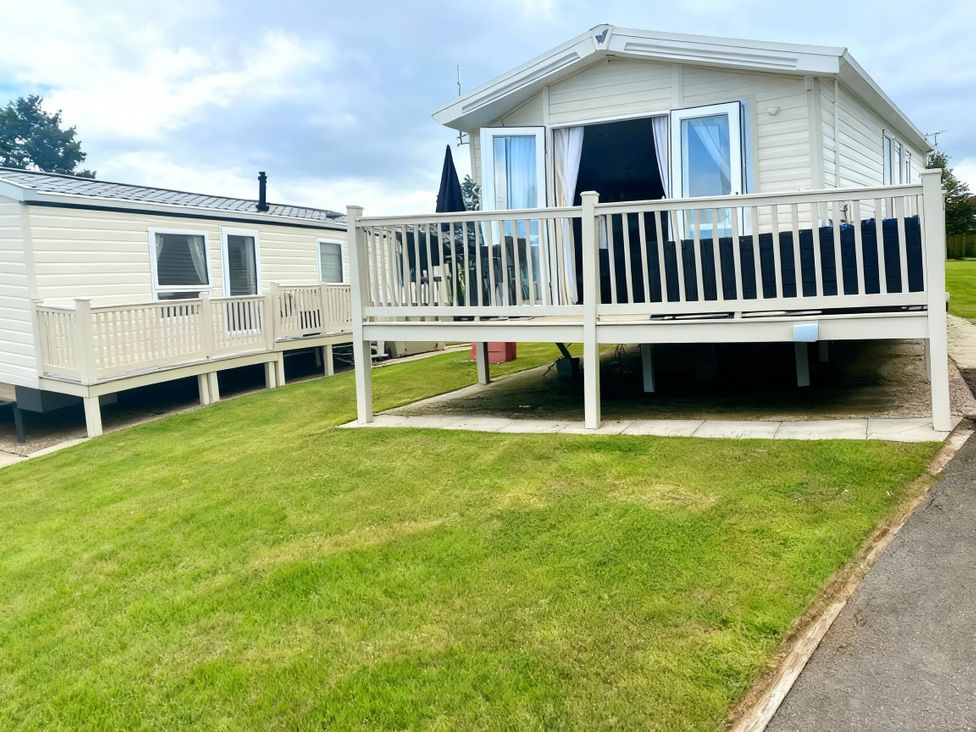 A holiday home with a deck and lawn at Thornwick Bay Holiday Village - Holiday Accommodation 20633, Flamborough