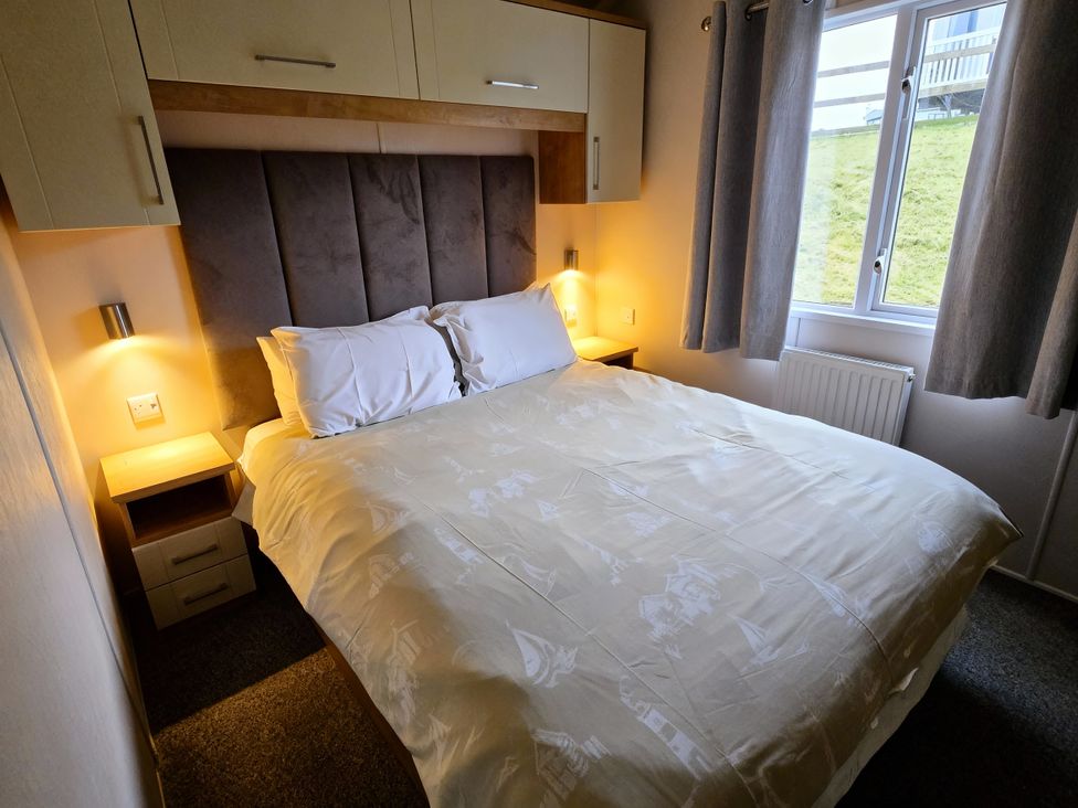 A bedroom with a double bed and bedside table at Thornwick Bay Holiday Village - Holiday Accommodation 20633, Flamborough