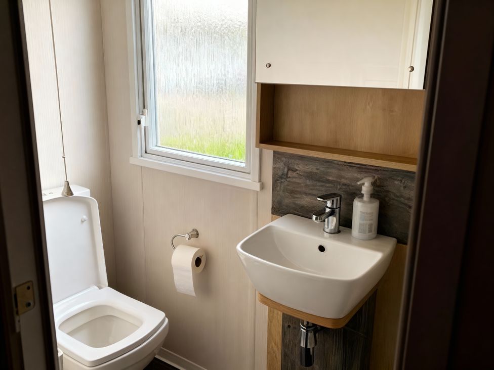 A bathroom with a toilet and sink at Lyons Robin Hood - Holiday Accommodation 20871, Rhyl