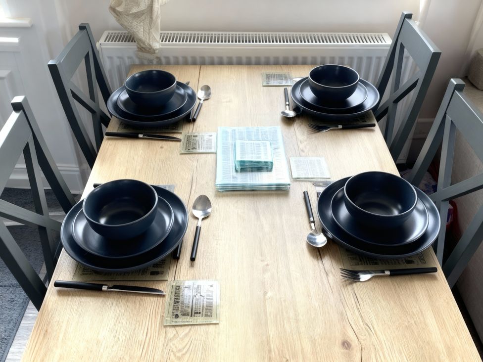A dining table set with bowls and cutlery at Lyons Robin Hood - Holiday Accommodation 20871 Rhyl