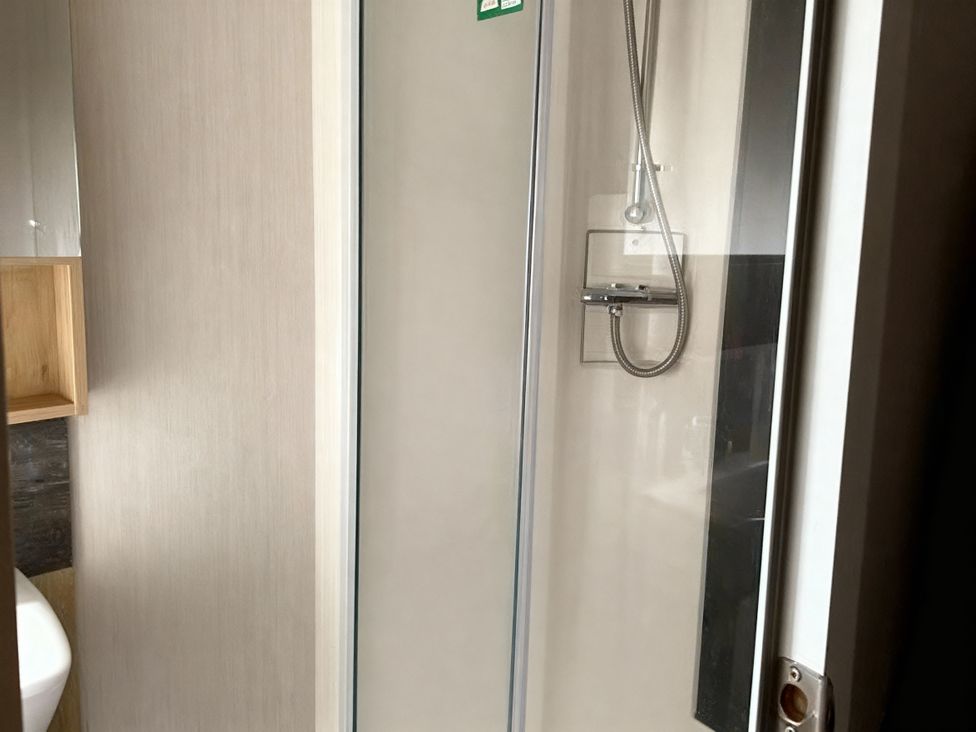 A shower with a glass door and showerhead at Lyons Robin Hood - Holiday Accommodation 20871 in Rhyl