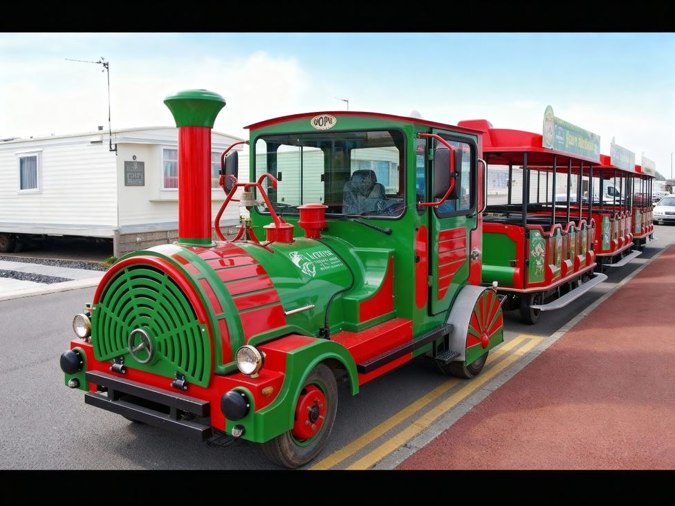 A colorful train with carriages on a road at Lyons Robin Hood - Holiday Accommodation 20871 Rhyl