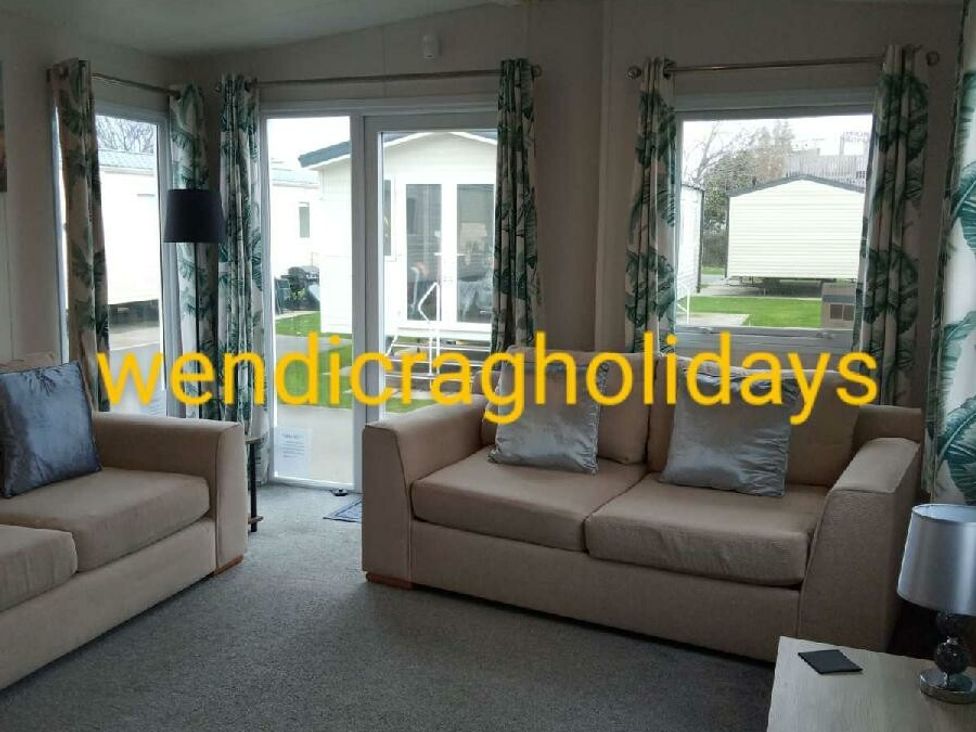 a living room with two sofas and glass doors at Ty Mawr Holiday Park - Holiday Accommodation 20936 Towyn