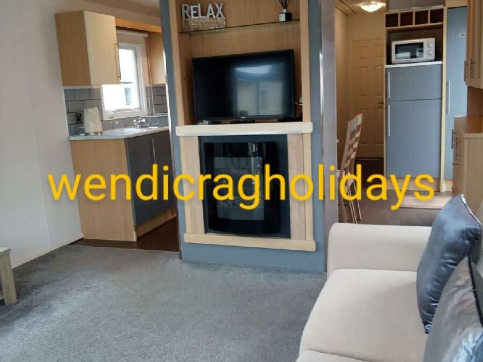 a living room with a television, kitchen units, and a dining area at Ty Mawr Holiday Park - Holiday Accommodation 20936 Towyn