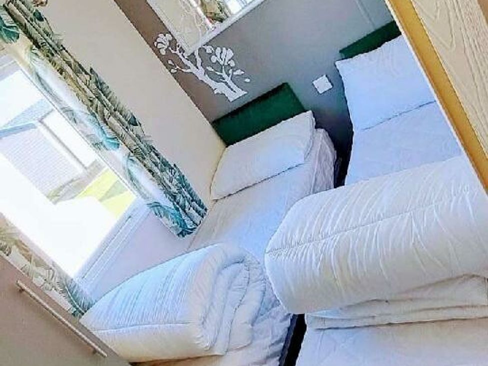 a bedroom with two single beds and bedding at Ty Mawr Holiday Park - Holiday Accommodation 20936 Towyn