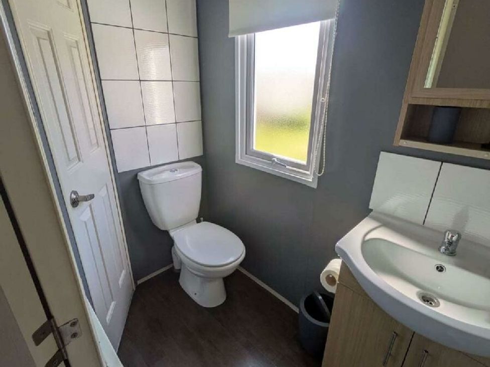 a bathroom with a toilet and sink at Ty Mawr Holiday Park - Holiday Accommodation 20936 in Towyn
