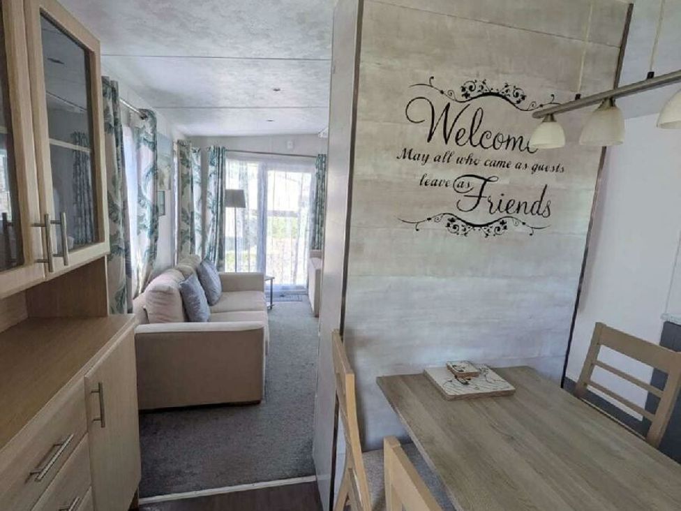 a seating area with a sofa and a dining table at Ty Mawr Holiday Park - Holiday Accommodation 20936 in Towyn