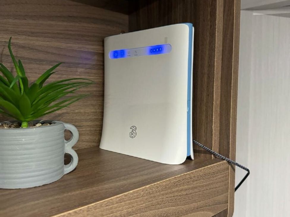 a white router on a wooden shelf next to a plant in a gray pot at Butlins Skegness - Holiday Accommodation 21028 Skegness