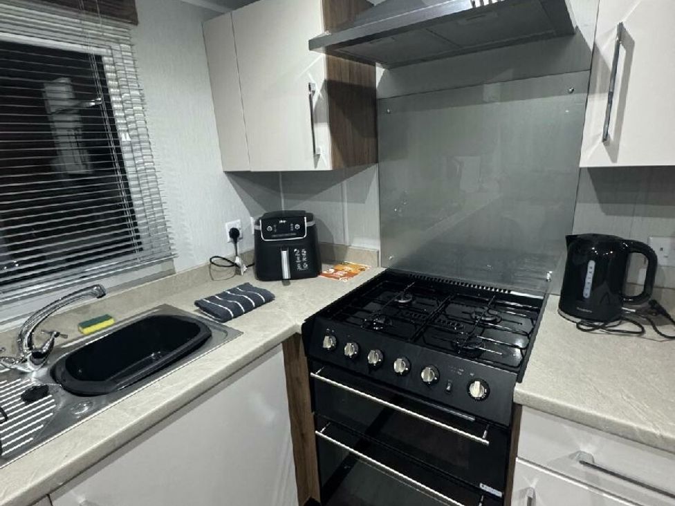 a kitchen with a gas stove, kettle, and sink at Butlins Skegness - Holiday Accommodation 21028 in Skegness